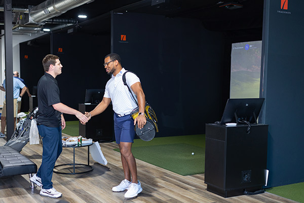 Handshake at indoor golf simulator. 